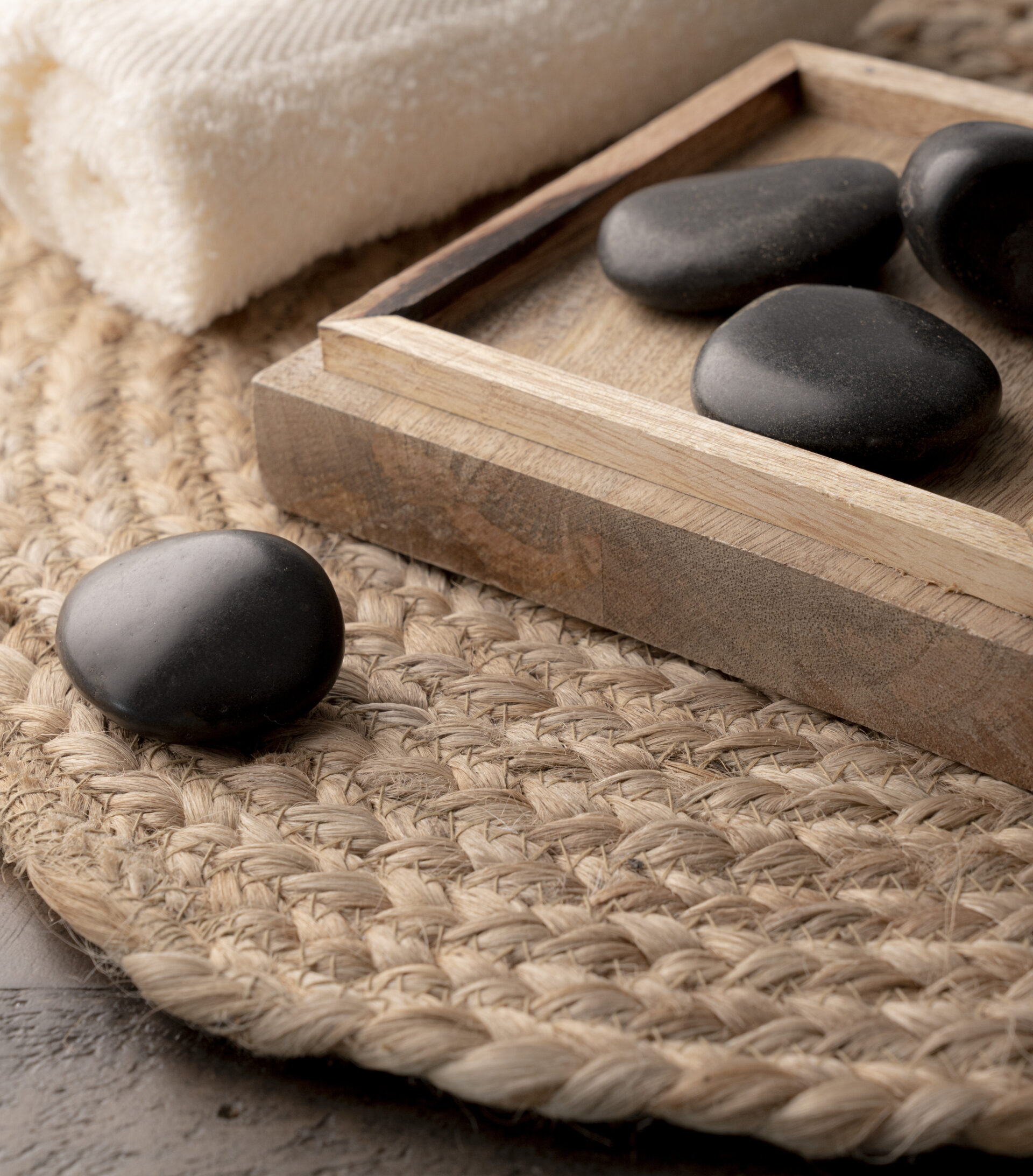 Hot stones in wooden tray next to bath towels - Young Living Lavender Life blog 