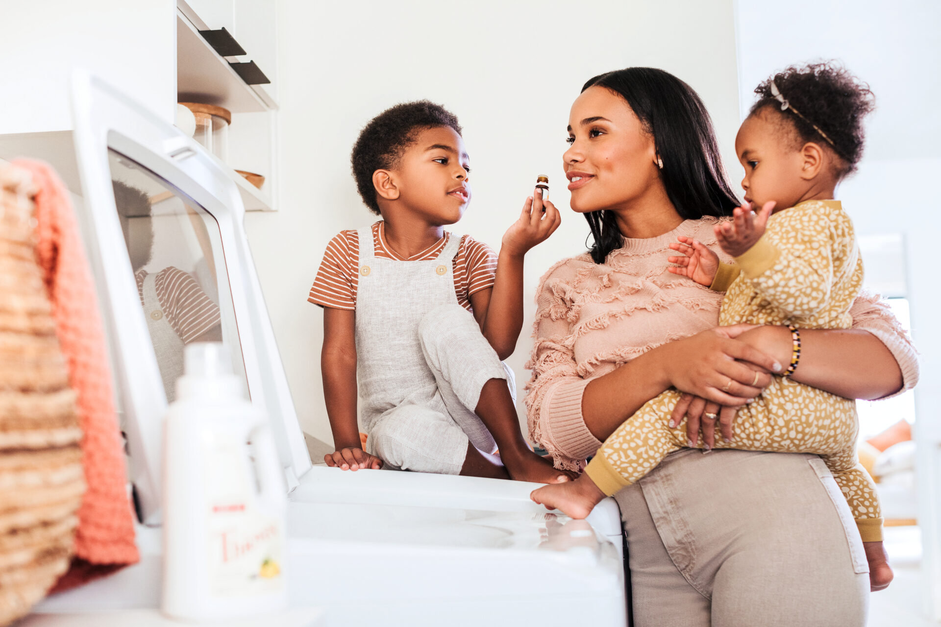 Mom doing laundry with her kids using Thieves Laundry Soap - Young Living Lavender Life blog 