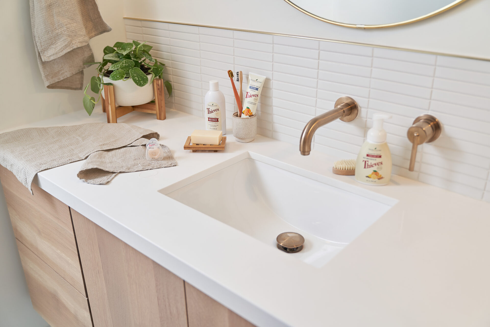 Bathroom vanity with Thieves hand soap, toothpaste, mouth wash, and floss - Young Living Lavender Life Blog 