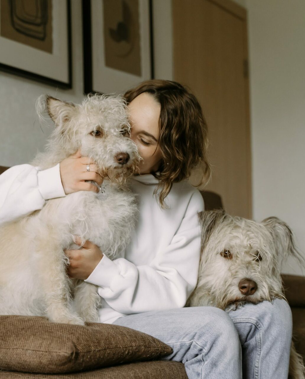 Woman sitting on couch with her two white dogs - Young Living Lavender Life Blog 