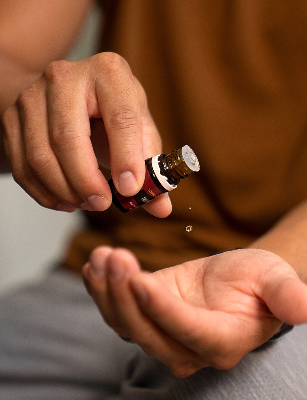 Man pouring essential oil drop into hand - Young Living Lavender Life Blog 