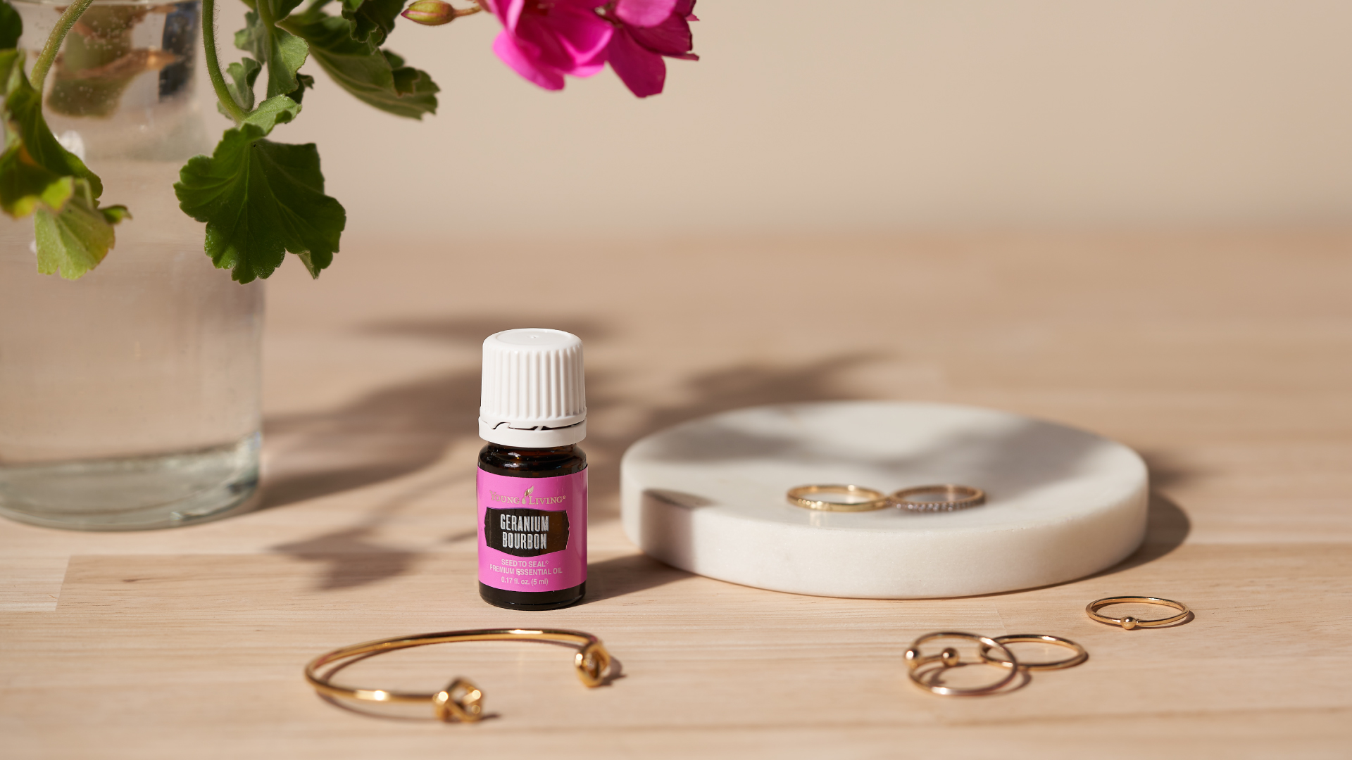 Geranium Bourbon Essential Oil next to Geranium flowers - Young Living Lavender Life Blog 