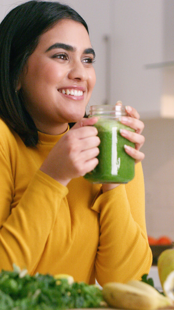 mujer bebiendo un batido verde saludable